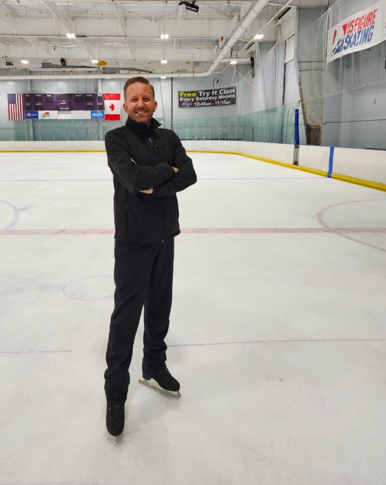 Skating coach Joshua Bindon standing in the middle of an ice rink